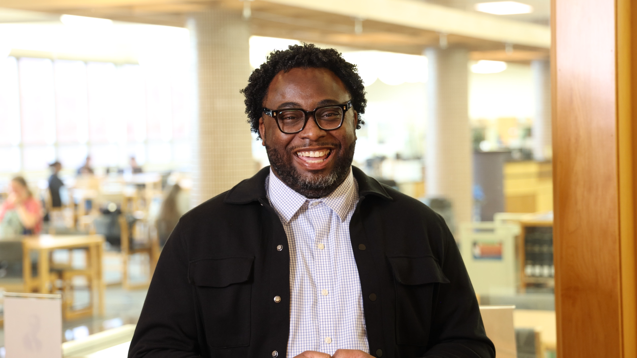 man with glasses and black jacket smiling