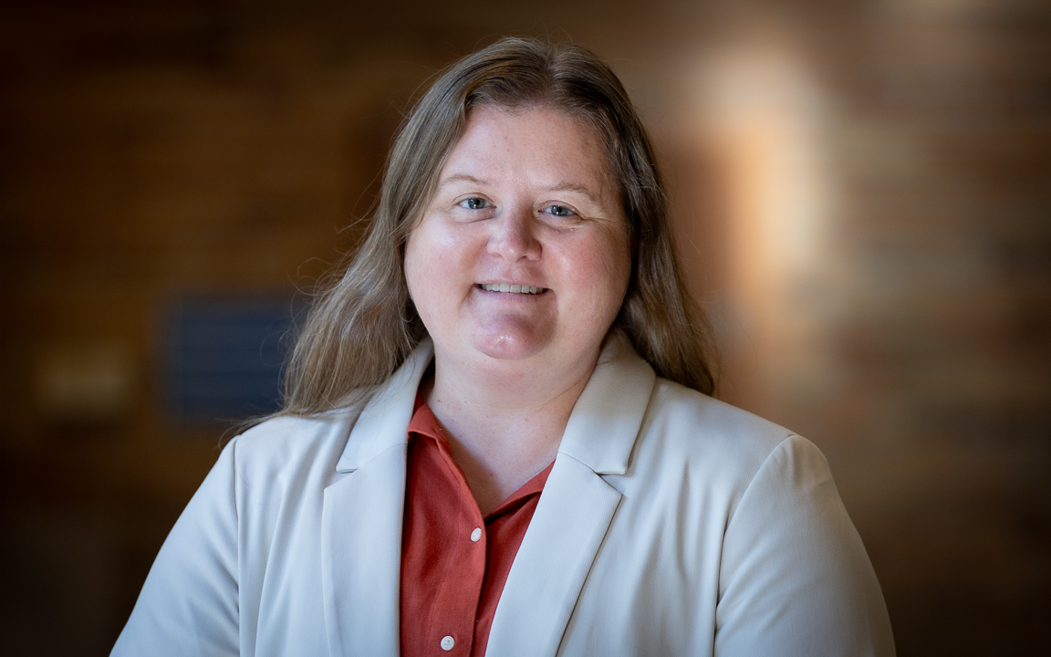 woman in white coat with short brown hair