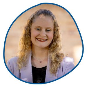 woman with curly blonde hair and purple shirt