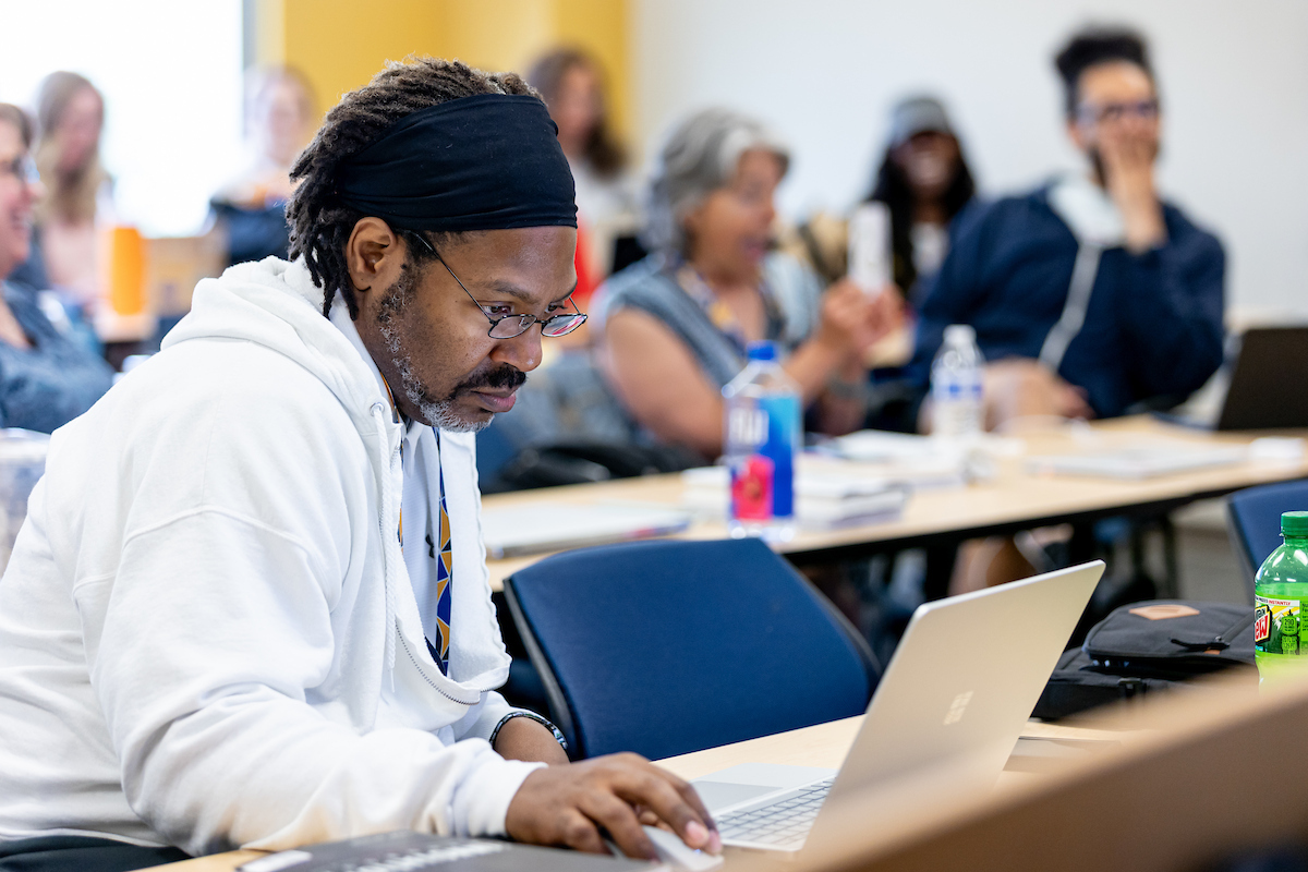 black man in class looking at computer
