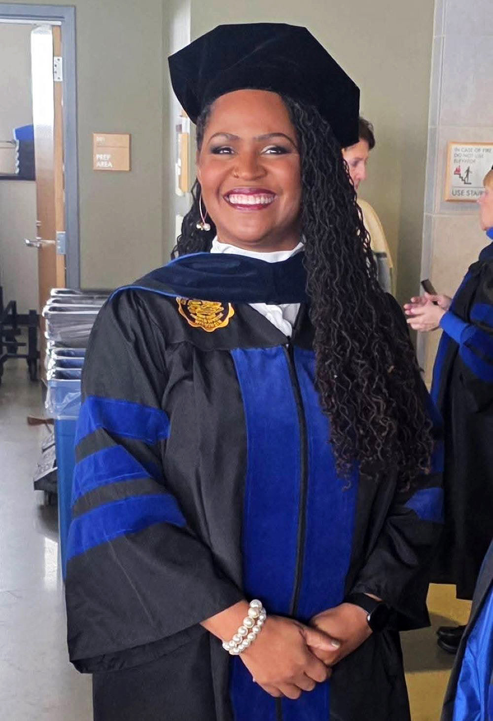 woman in gown and cap with long black hair