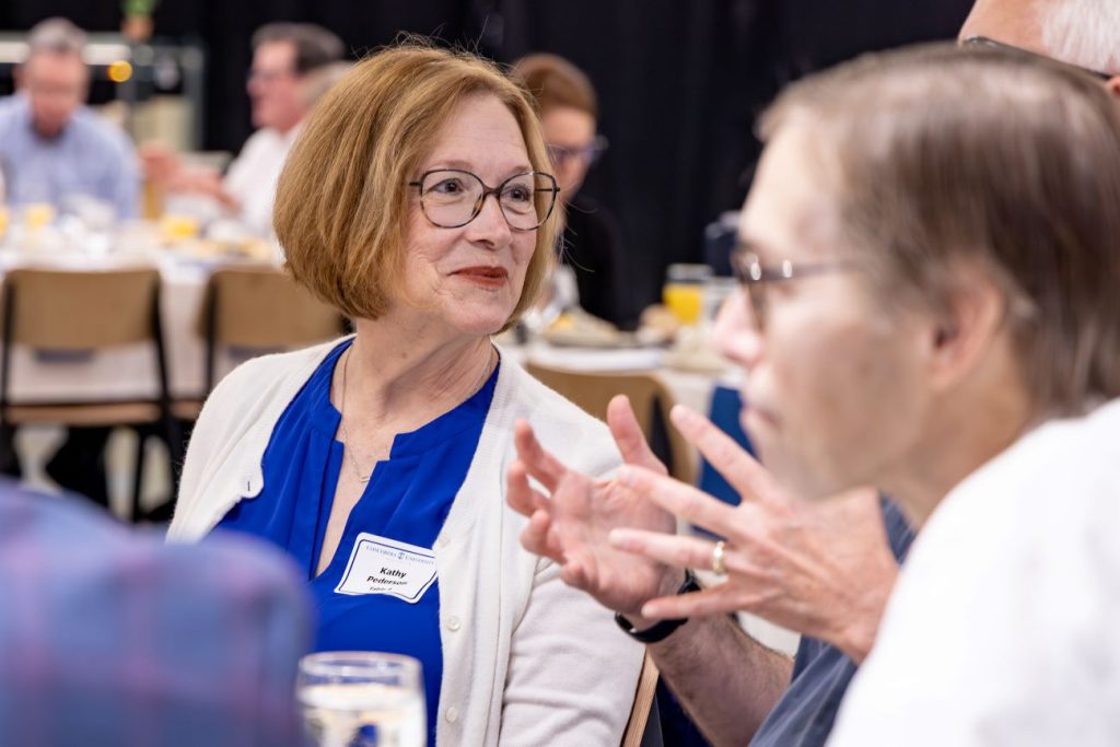 woman smiling with glasses and white sweater