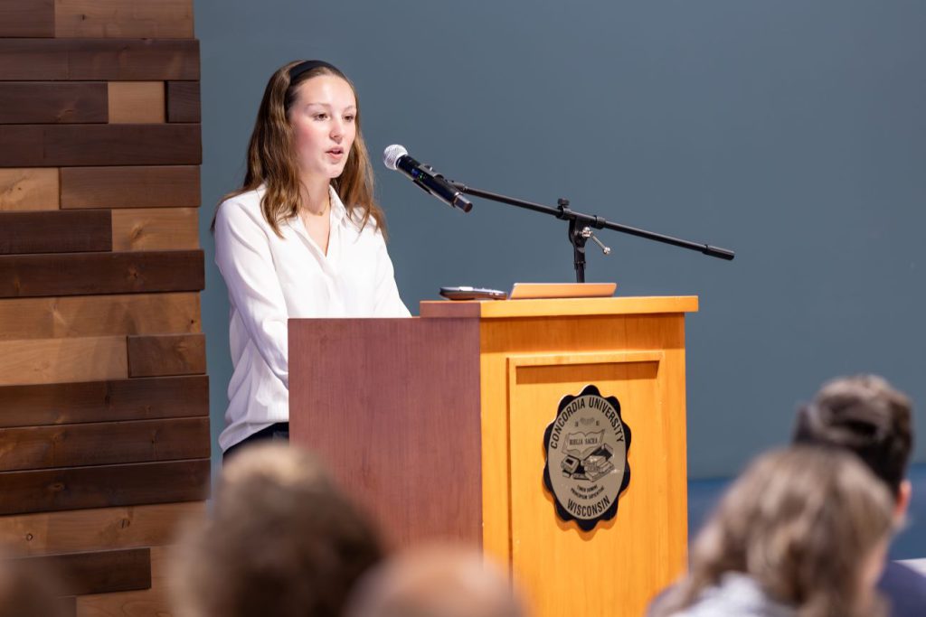 woman in white shirt at podium