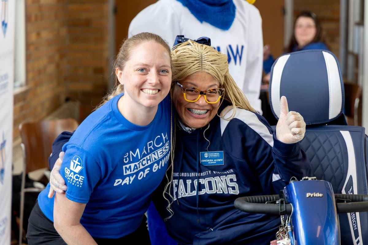 students hugging with one giving a thumb's up