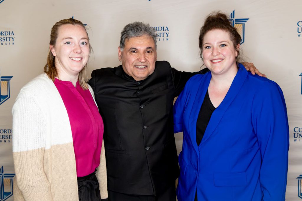 man with two woman smiling at camera