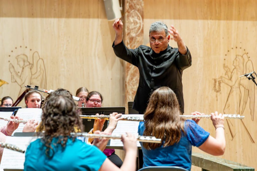 man instructing students playing flutes