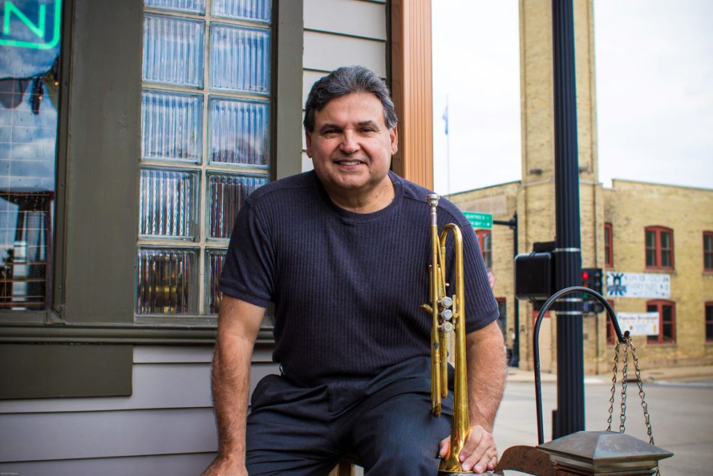 man with instrument outside of a business