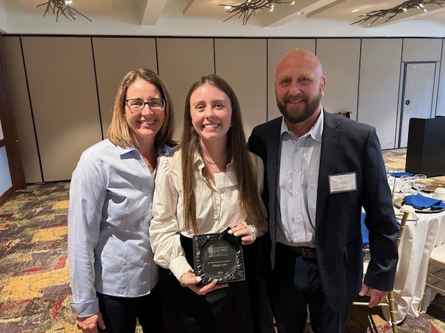 girl with her parents holding award