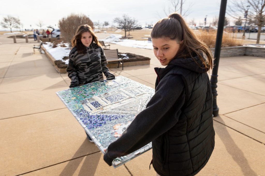 Girls carrying mosaic panel