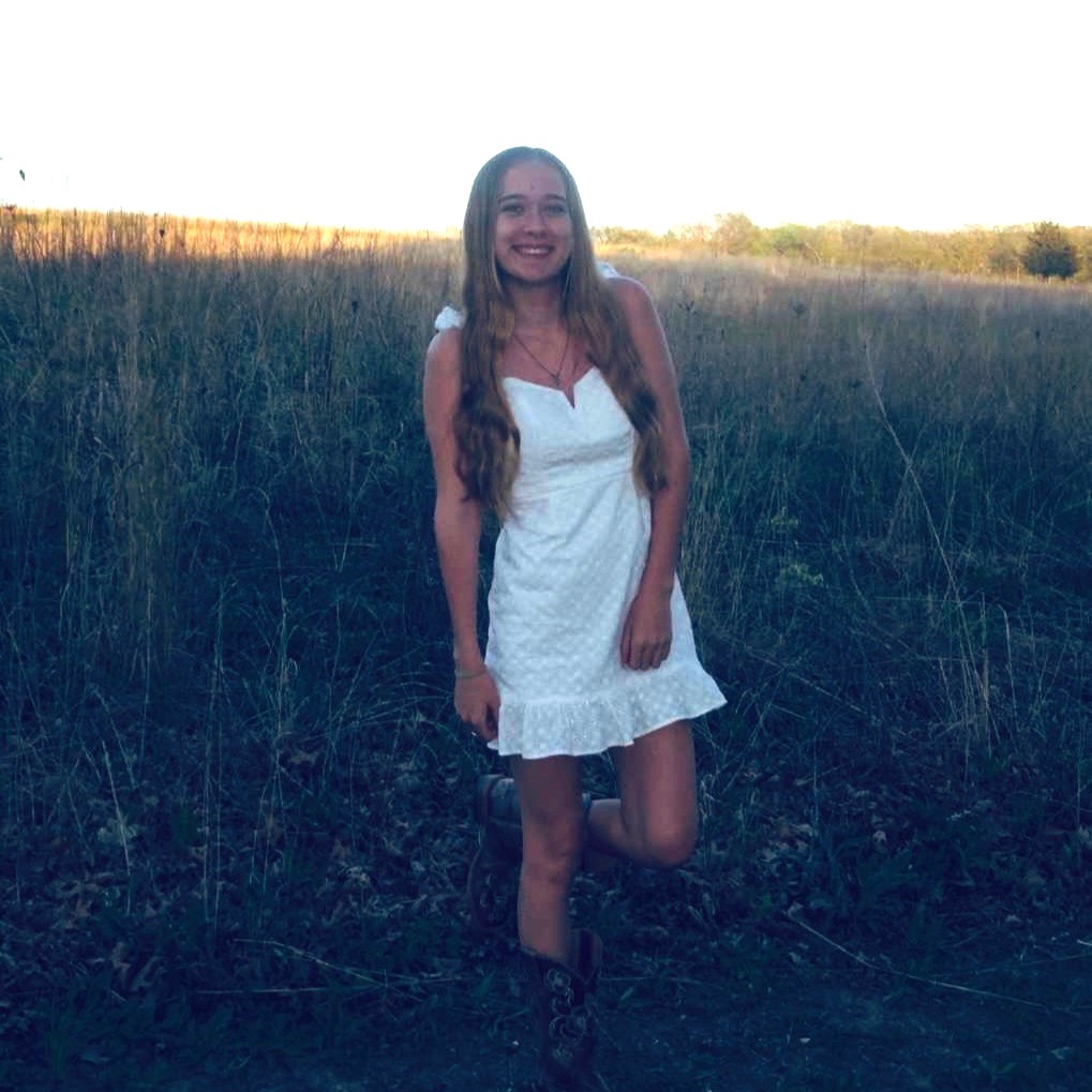 girl in white dress in field