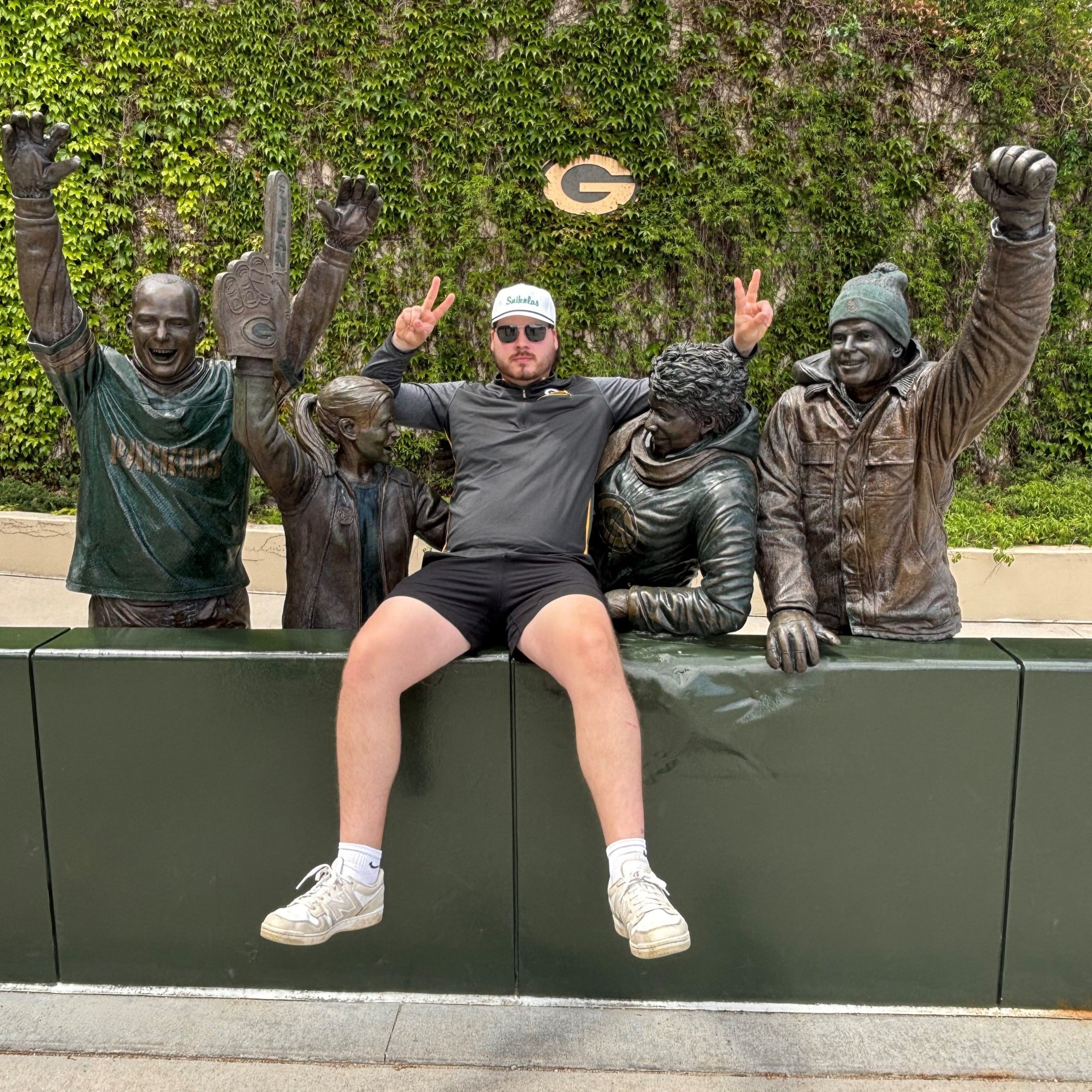 guy sitting down by statues
