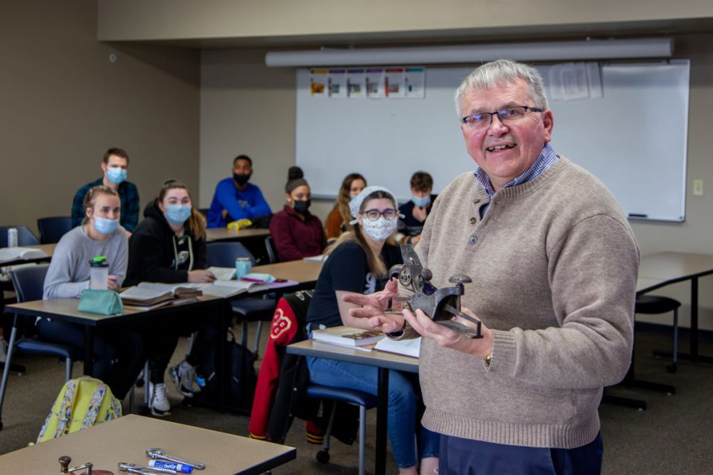 man smiling in front of classroom