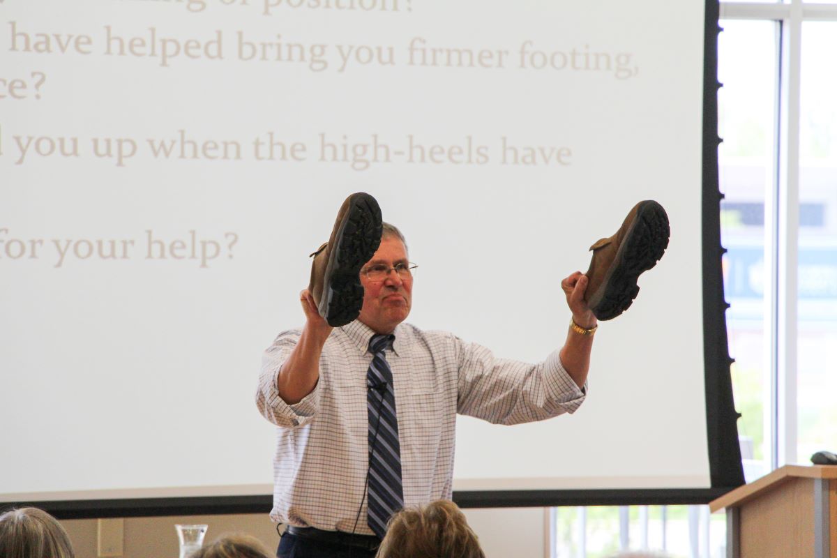 men teaching with shoes in his hands