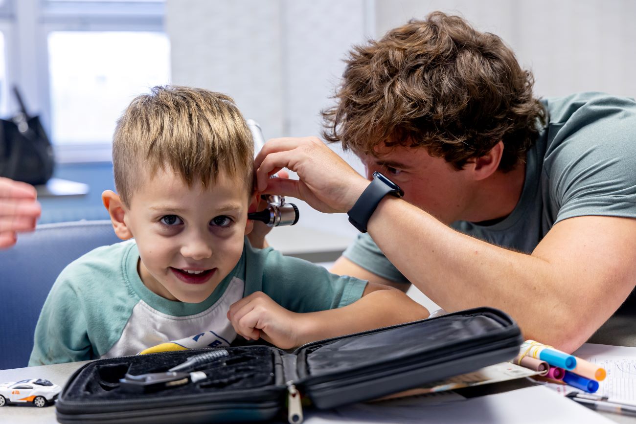 male nurse looking at boy's ear