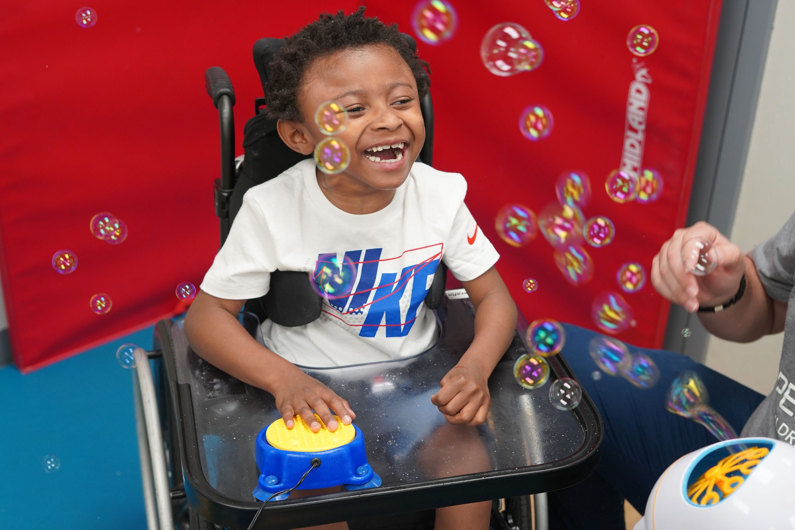 kid hitting a button with bubbles