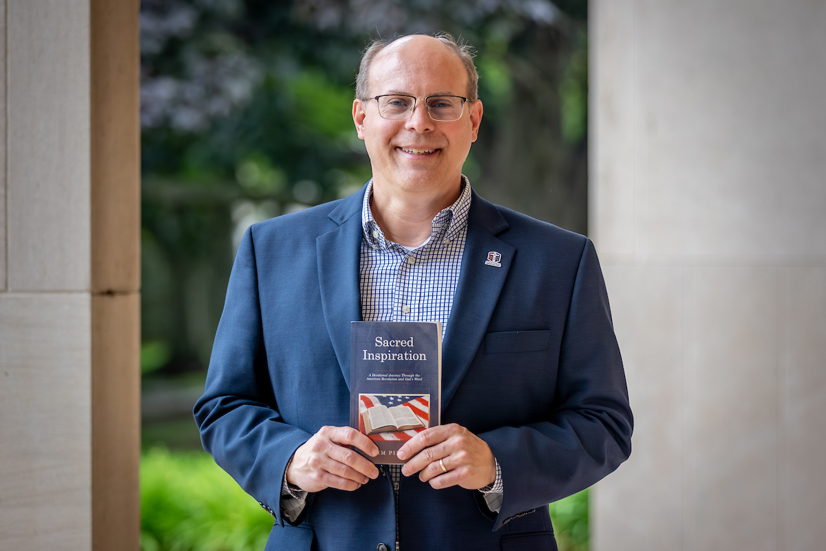 Jim Pingel holding the book he wrote