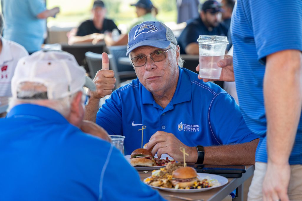 guy eating with his thumb up