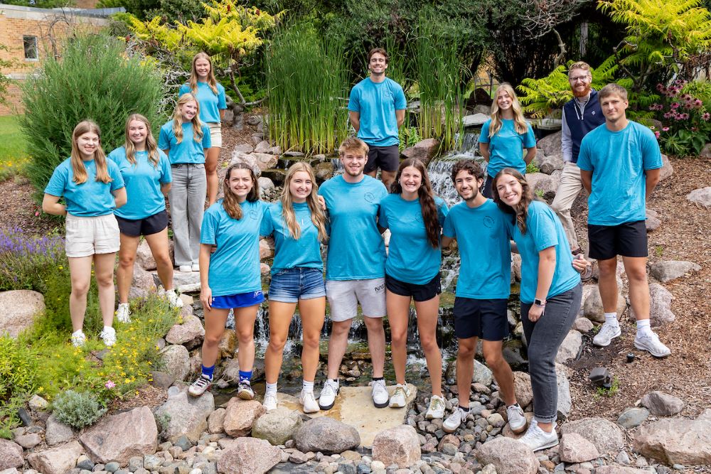 bunch of students in blue shirts on rocks
