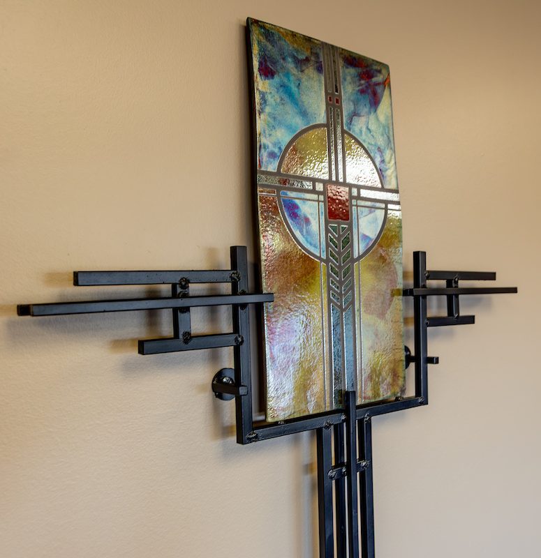 A cross made out of colored glass and ironwork