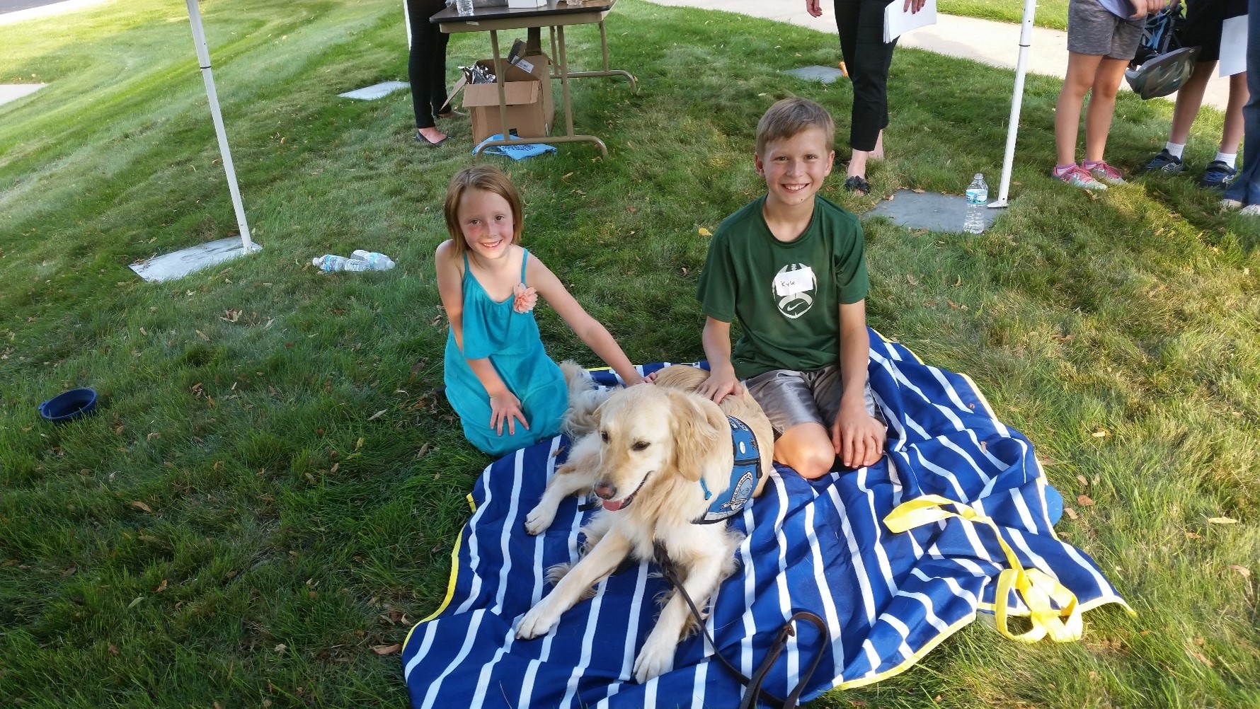 dog with two kids on blanket