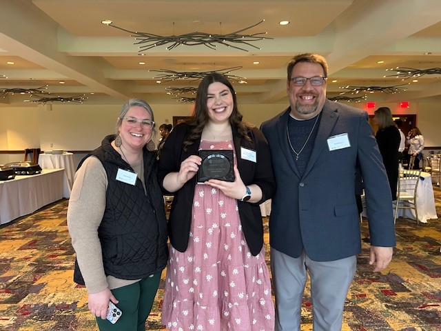 girl with award and parents