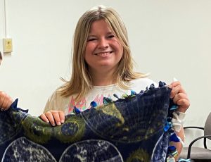 woman holding a tie blanket