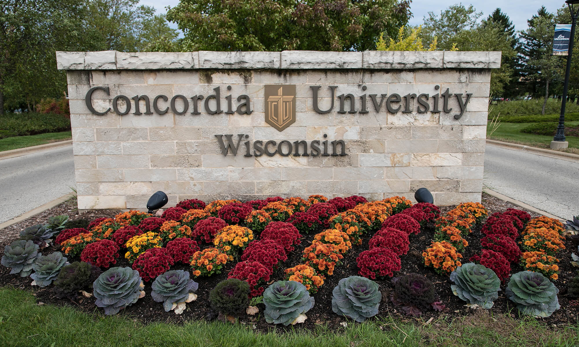 Concordia sign with foliage planted in front.