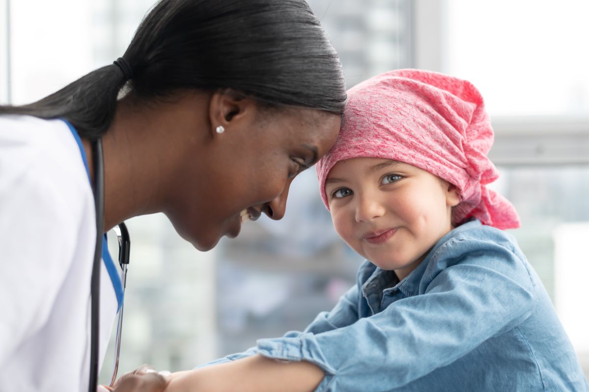 a little girl with pink head piece and black woman